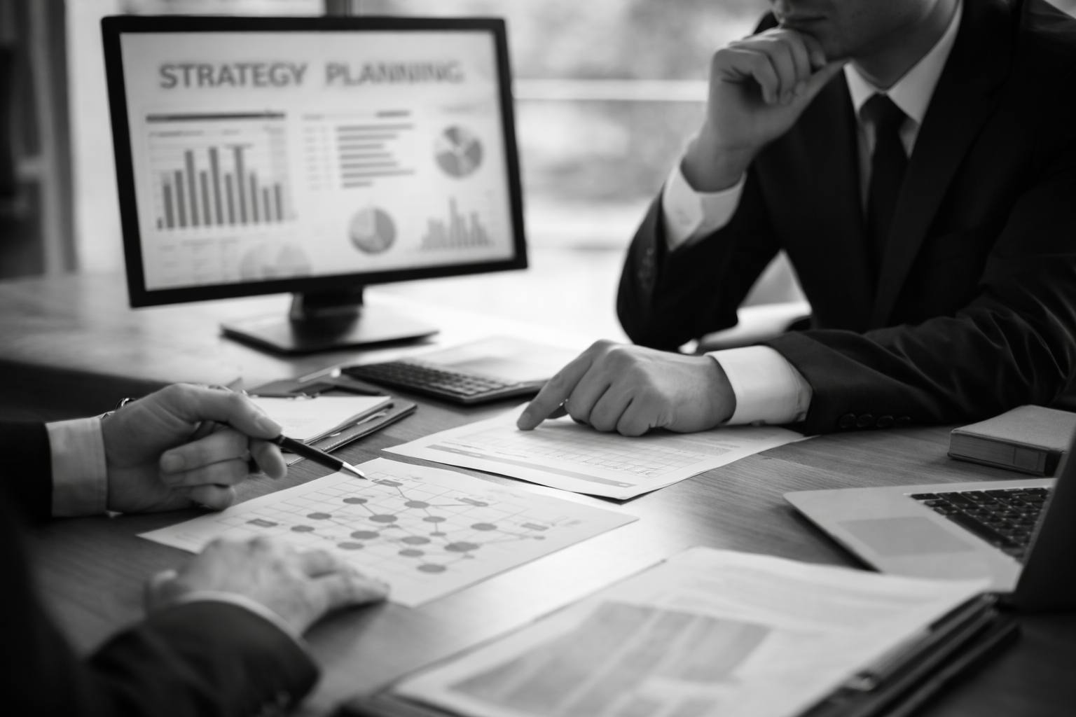 Profesionales revisando documentación y estructura empresarial en una reunión de planificación estratégica